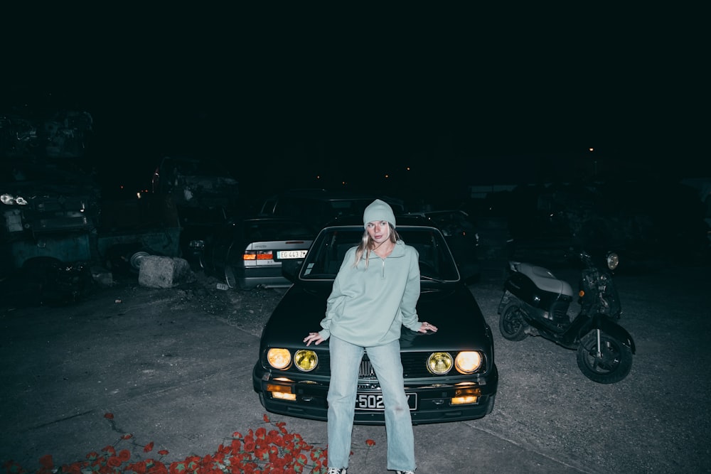 a woman sitting on the hood of a car