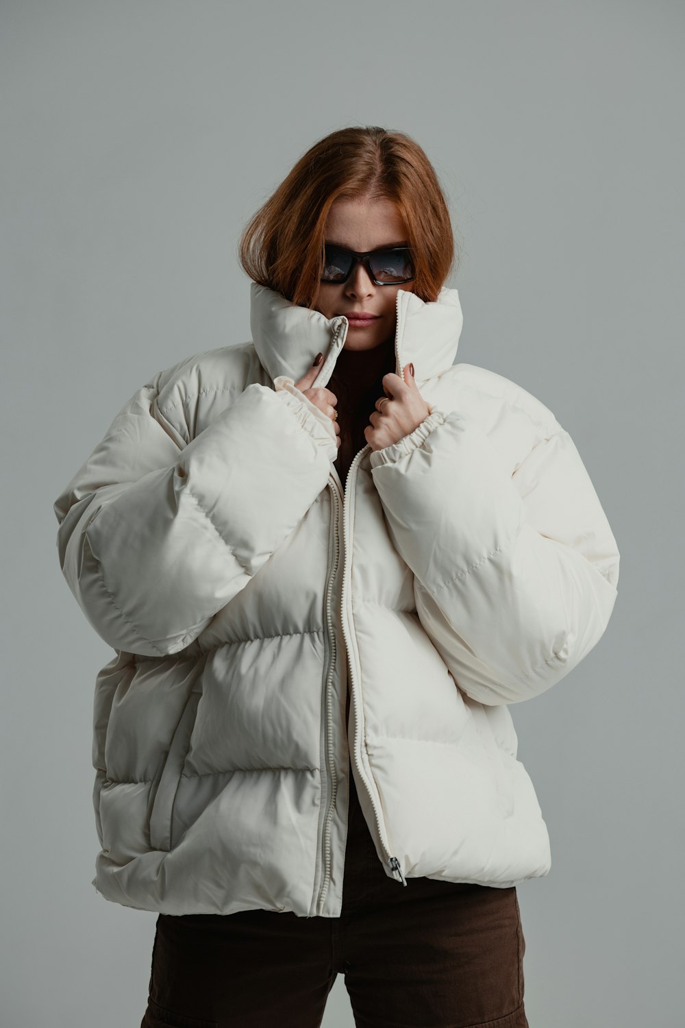 une femme portant une veste blanche et des lunettes de soleil