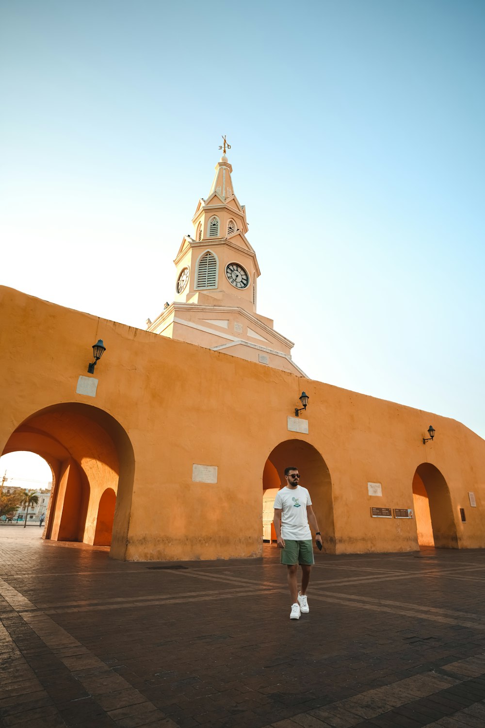 a man standing in front of a building with a clock tower