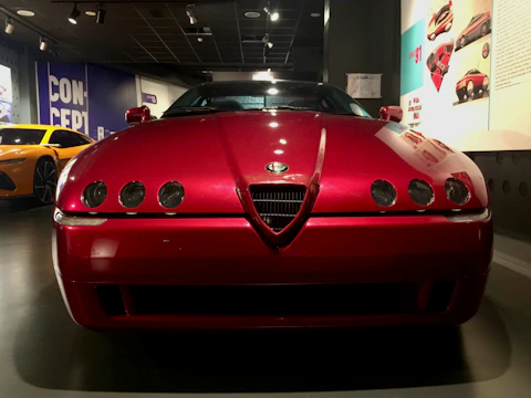 A shiny red sports car gleaming under showroom lights.