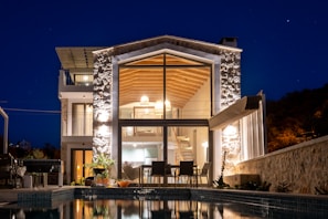 a house with a swimming pool at night