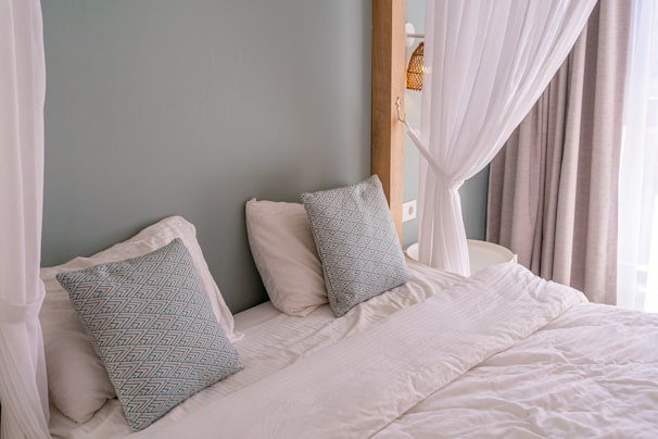 Elegant double bed with crisp white linens and decorative pillows.