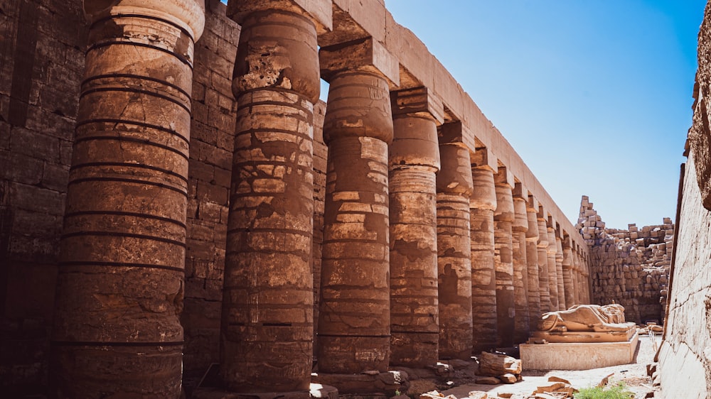 a row of large stone pillars next to a building