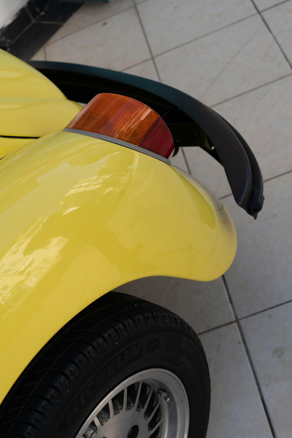 a close up of a yellow car on a tile floor