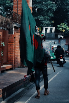 a person walking down a street holding a green flag