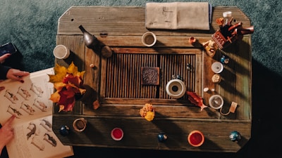 Detail of handcrafted artistic objects arranged on a wooden table.