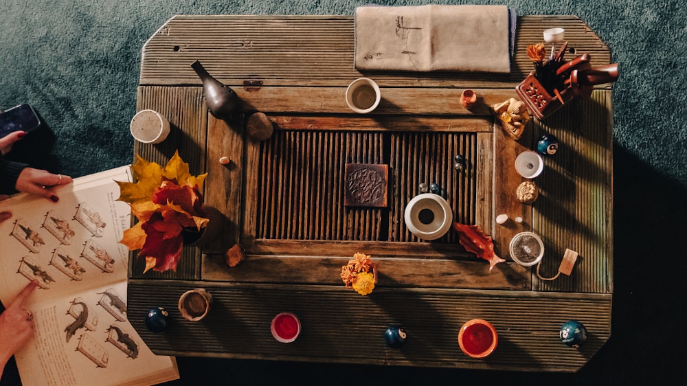 a wooden table topped with dishes and cups