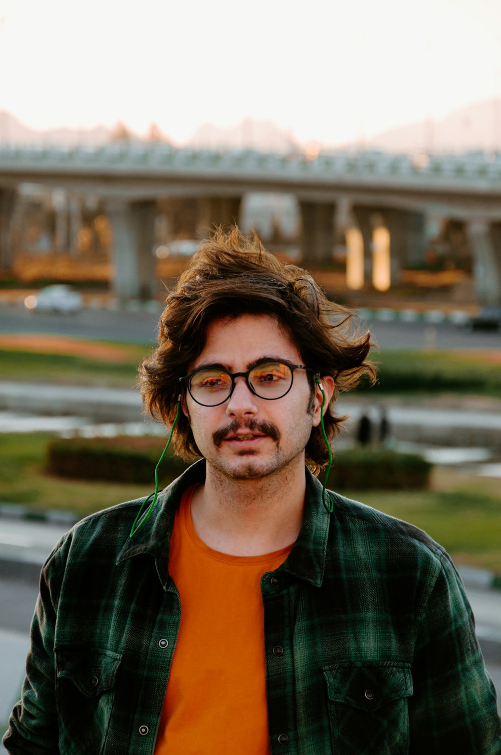 a man wearing glasses and a green and orange shirt