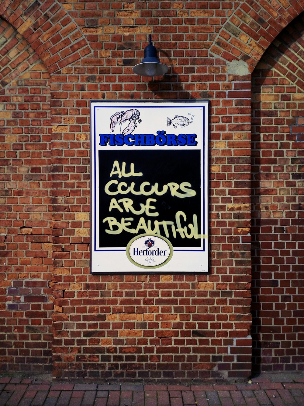 a sign on a brick wall that says all colours are beautiful