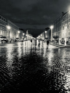 Urban nighttime street with wet cobblestones reflecting neon lights.
