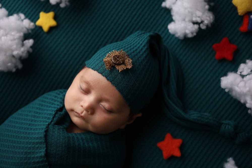 ein Neugeborenes mit grünem Hut und grünem Pullover