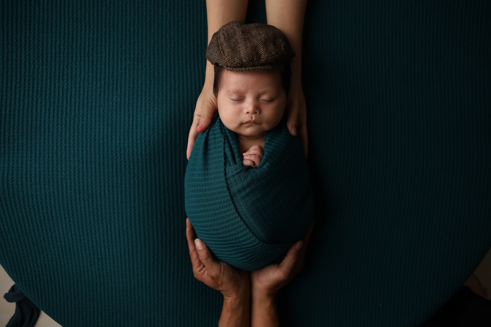 Eine Frau, die ein Baby in eine Decke gewickelt hält