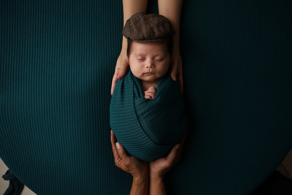 a woman holding a baby wrapped in a blanket