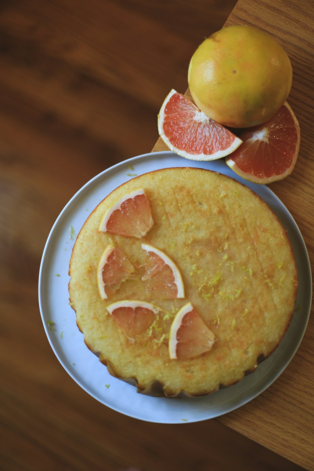 a cake on a plate with oranges and a grapefruit