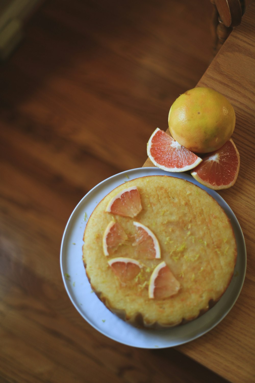 a cake on a plate with oranges and a grapefruit