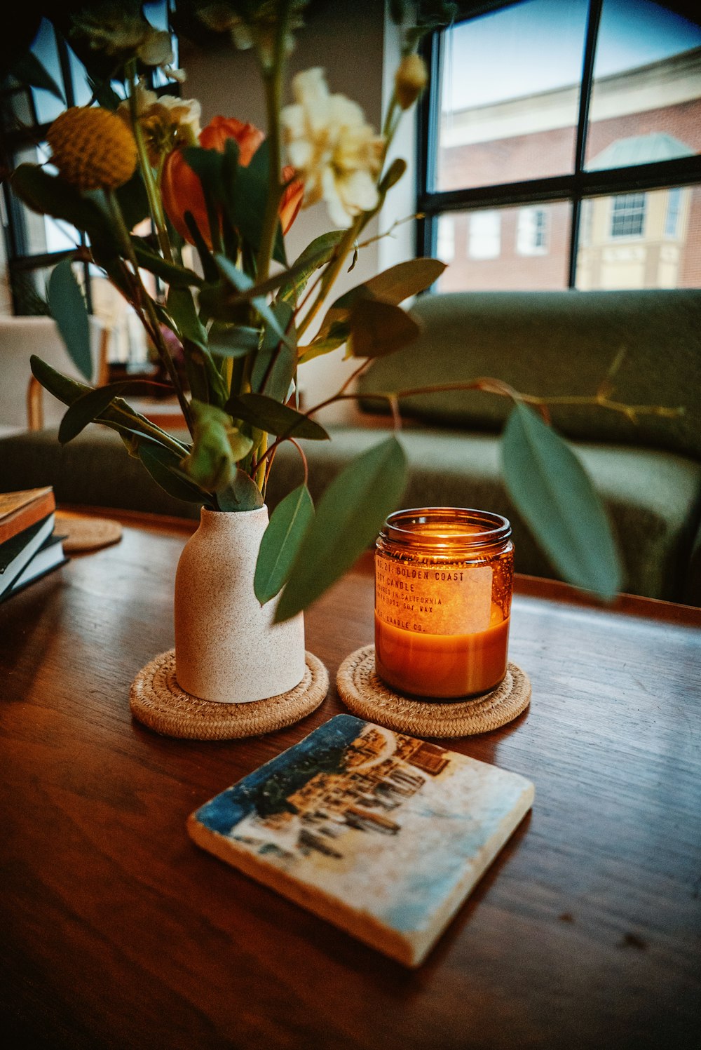 a candle sits on a table next to a book