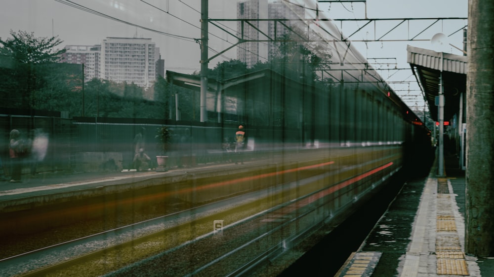 a train traveling down train tracks next to a tall building