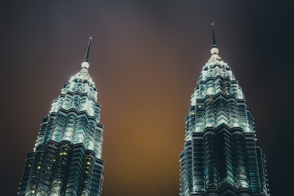 two very tall buildings lit up at night