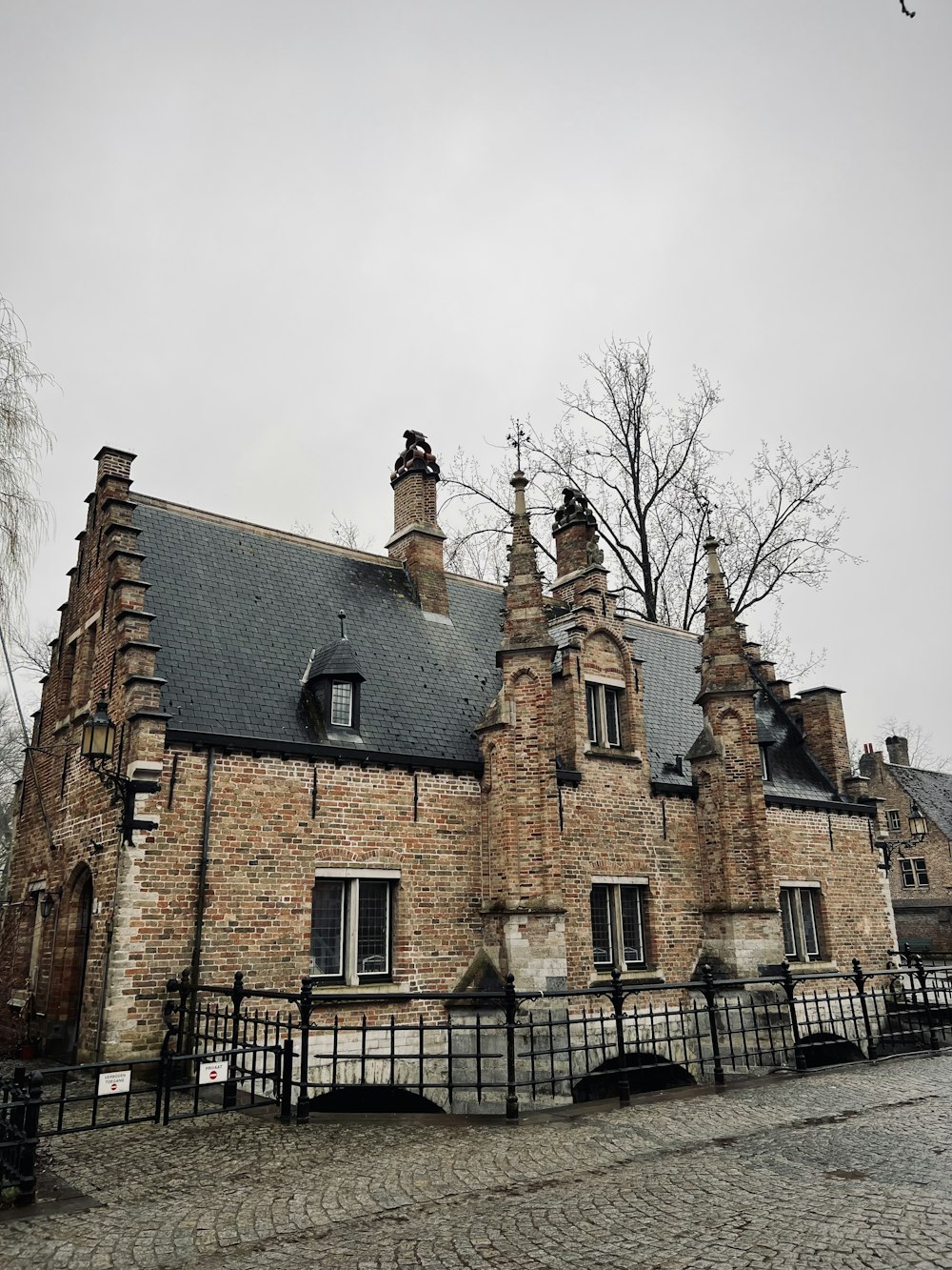 a large brick building with a black fence around it