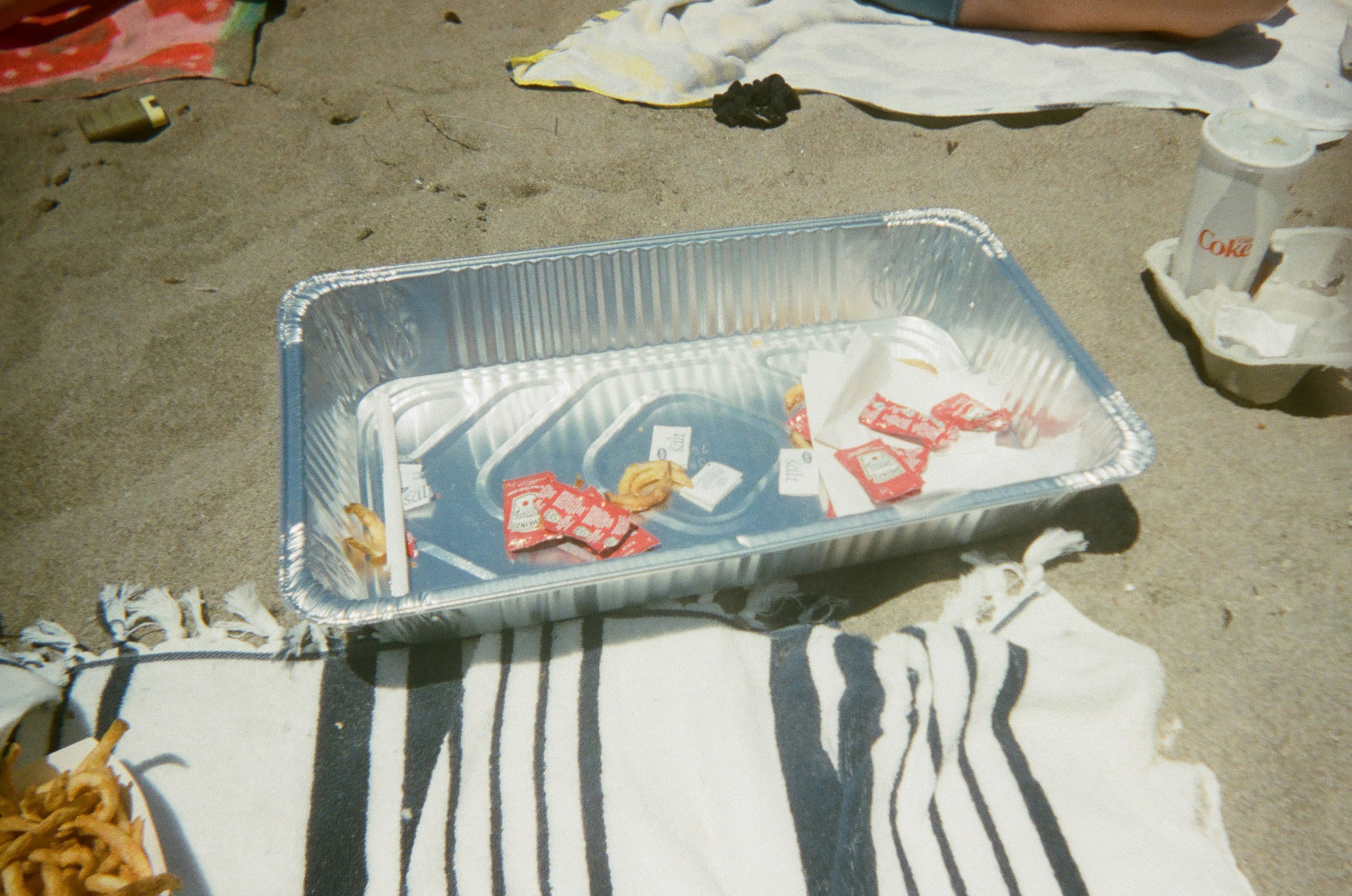 un récipient en plastique rempli de nourriture au-dessus d’une plage