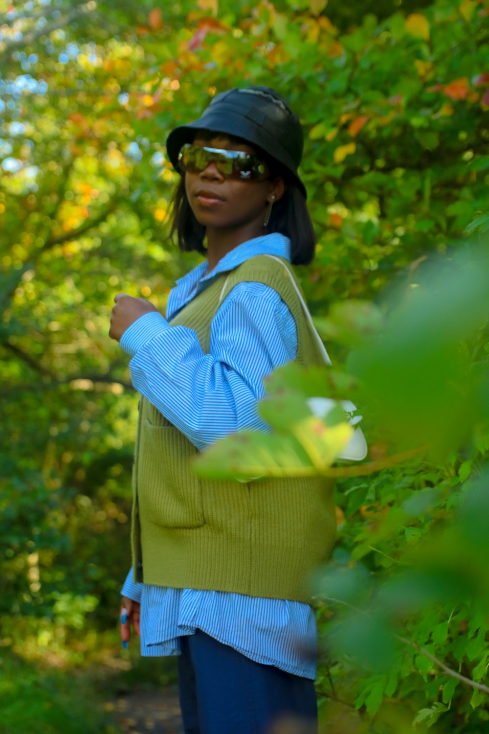 a woman wearing a green vest and a black hat