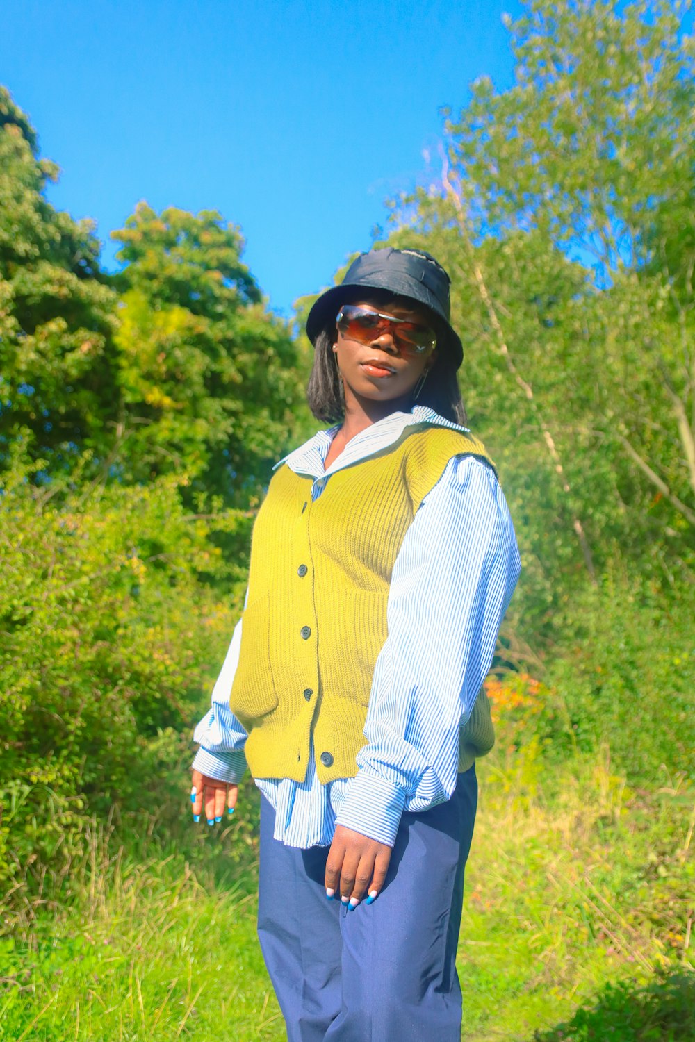 a woman standing in a field wearing a yellow vest