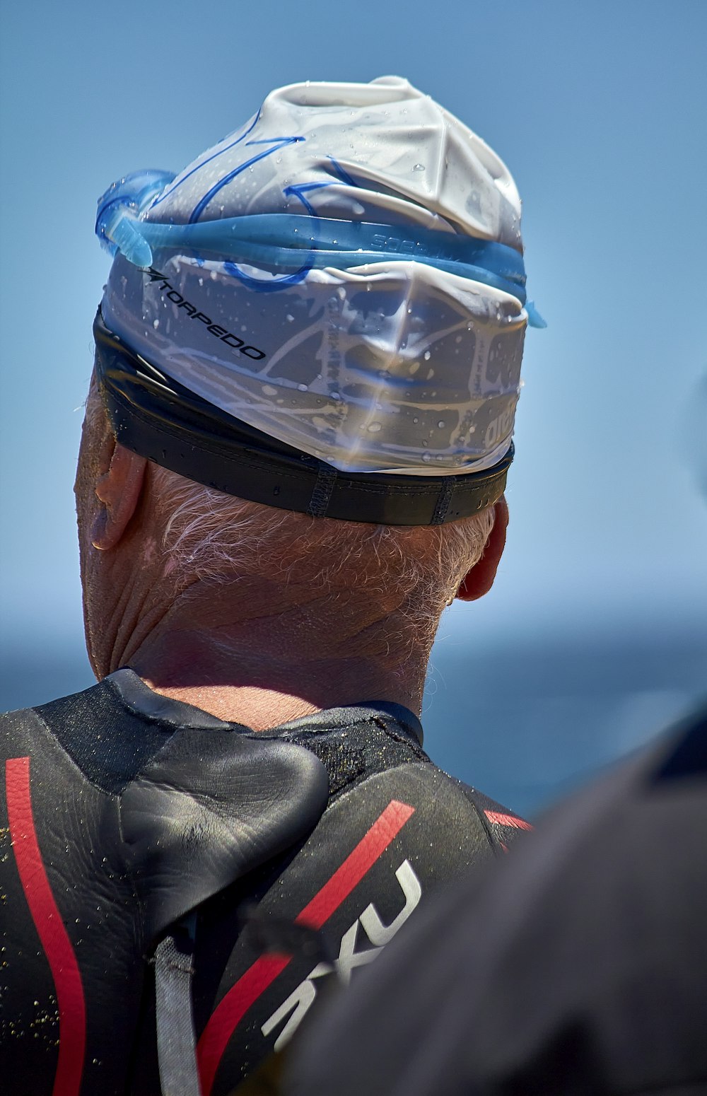 Un uomo che indossa un elmetto protettivo che guarda l'oceano