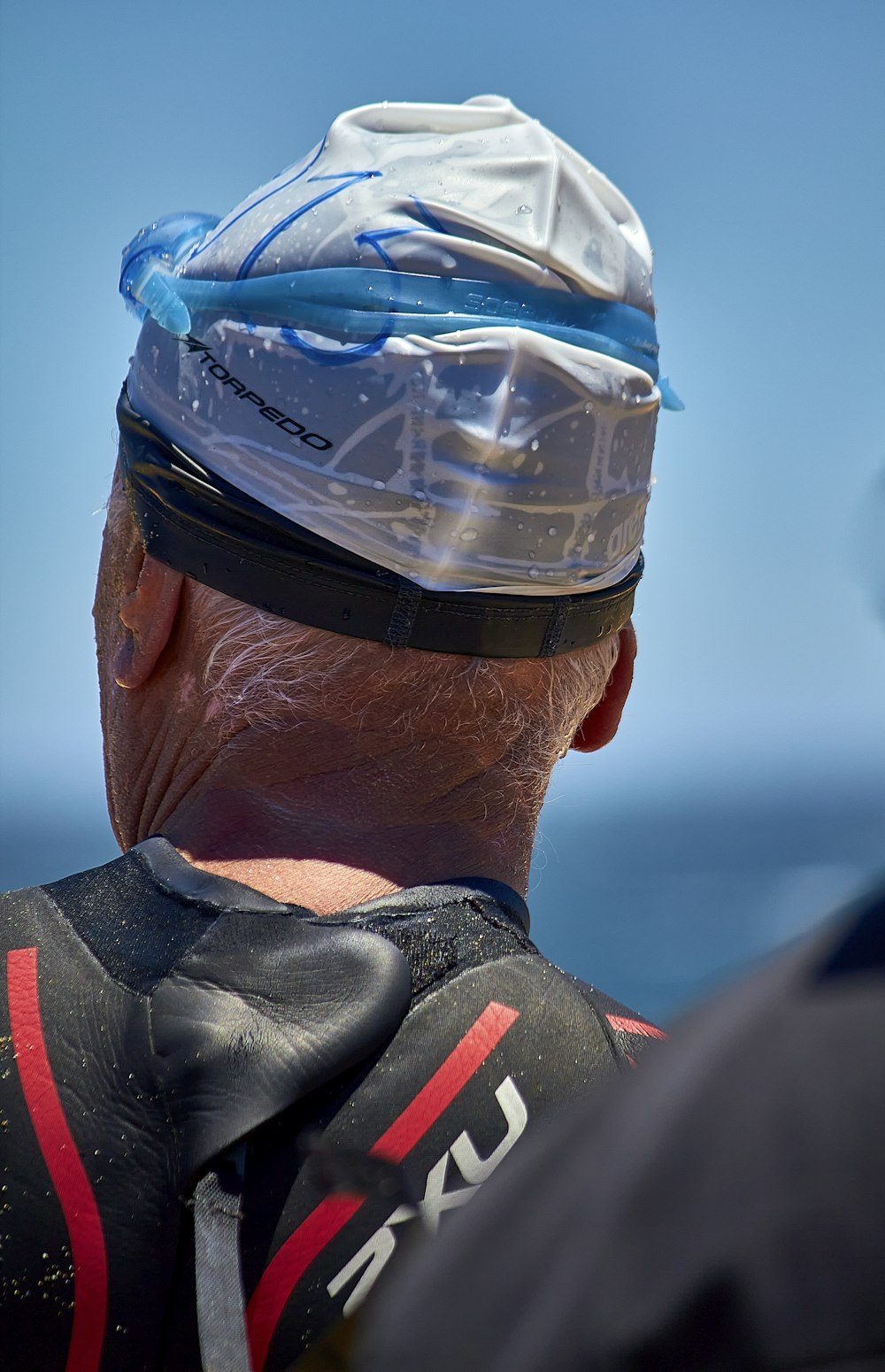 a man wearing a protective helmet looking out at the ocean