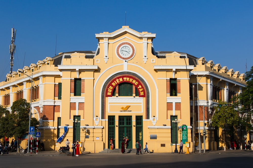 a large yellow building with a clock on the front of it