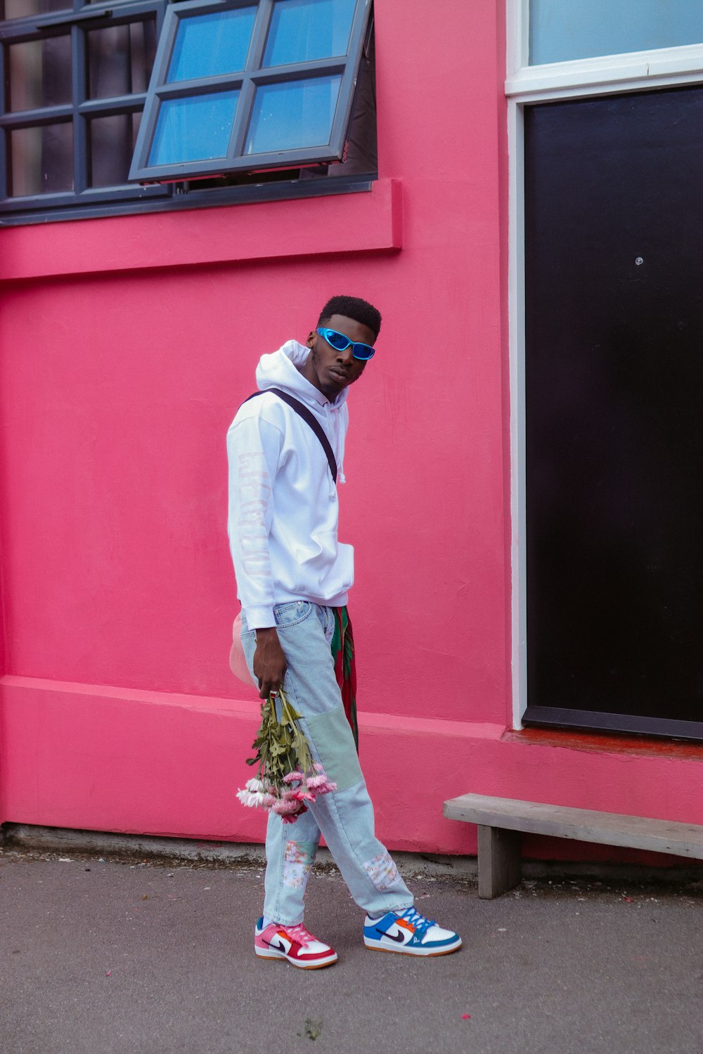 a man walking down the street in front of a pink building