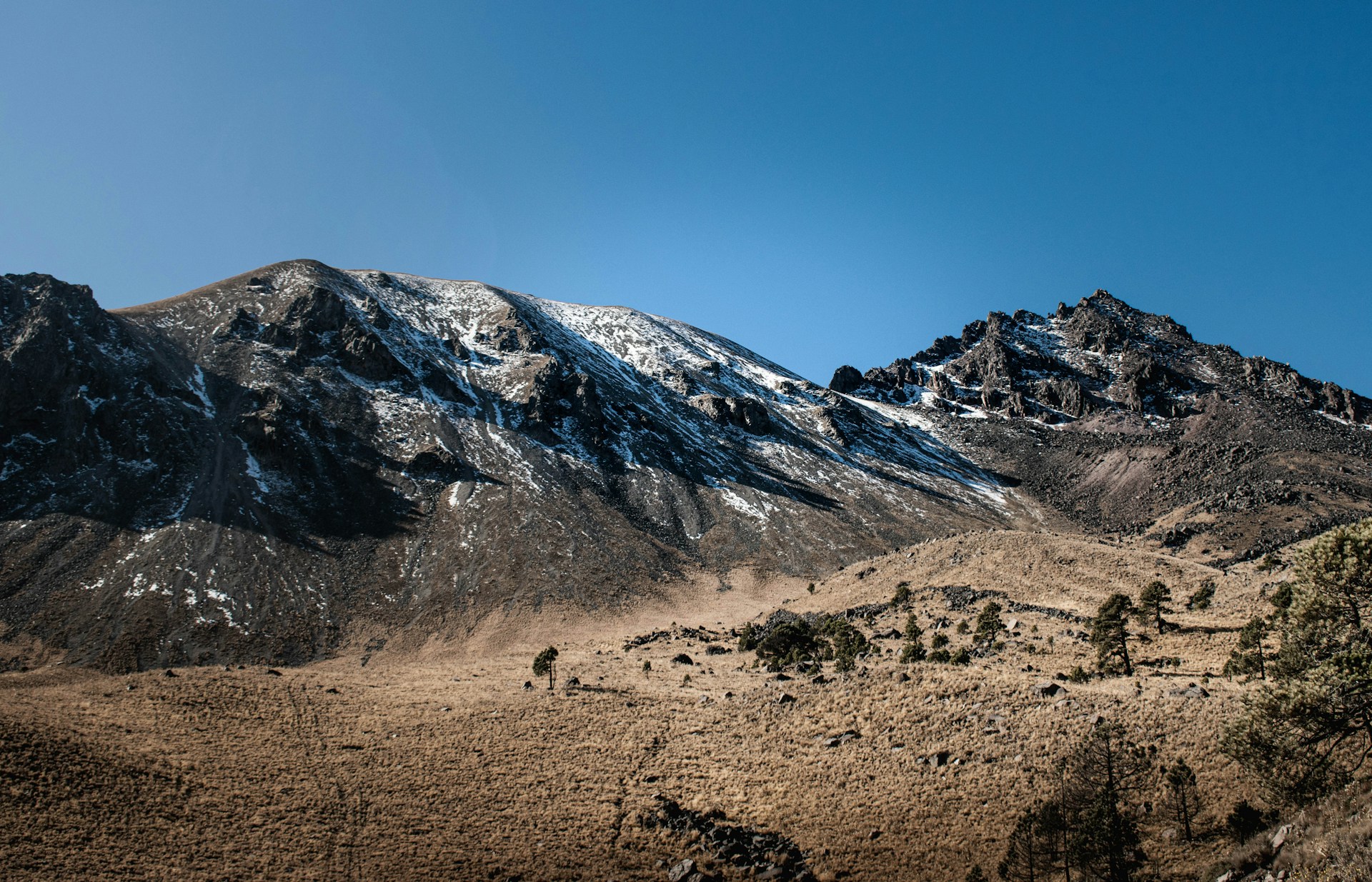 a snow covered mountain range with a clear blue sky