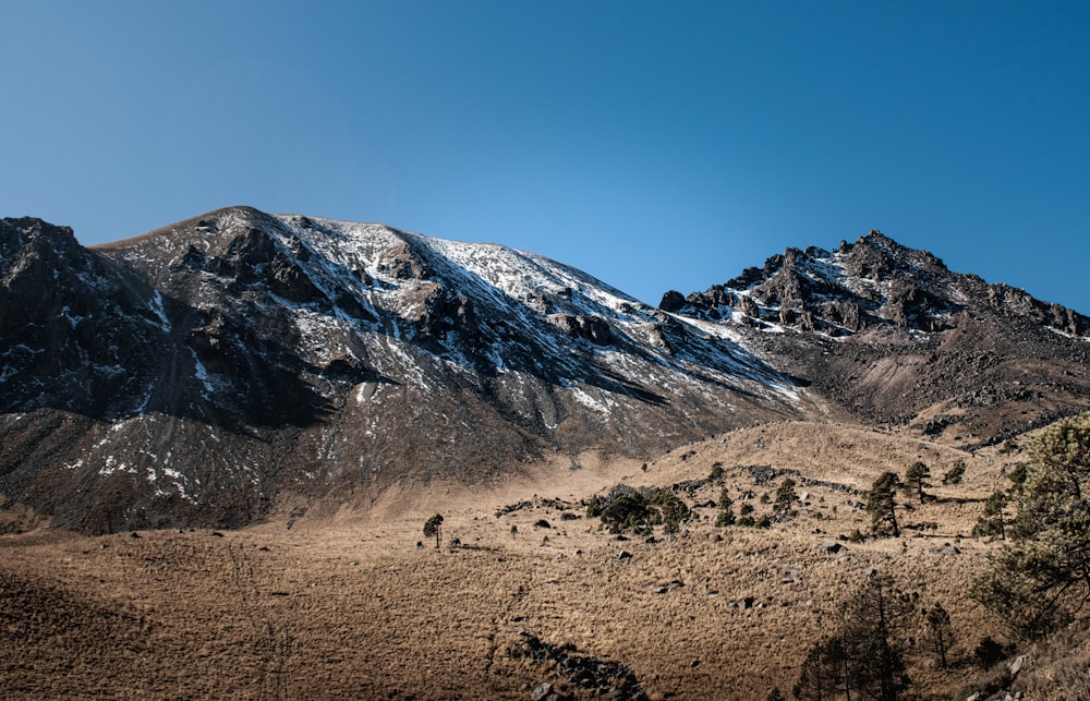 a snow covered mountain range with a clear blue sky