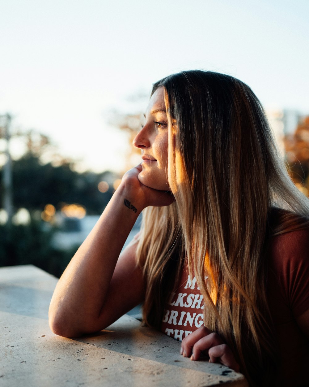 a woman sitting at a table with her hand on her chin