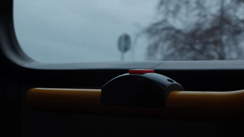 Close-up of a handicap auto door button mounted on a brick wall.
