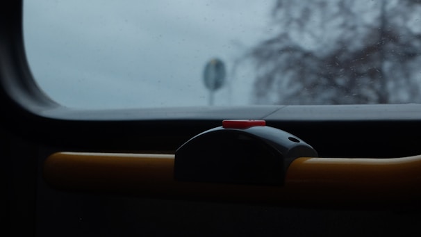 Bright orange emergency button on a mobile device screen with blurred road background