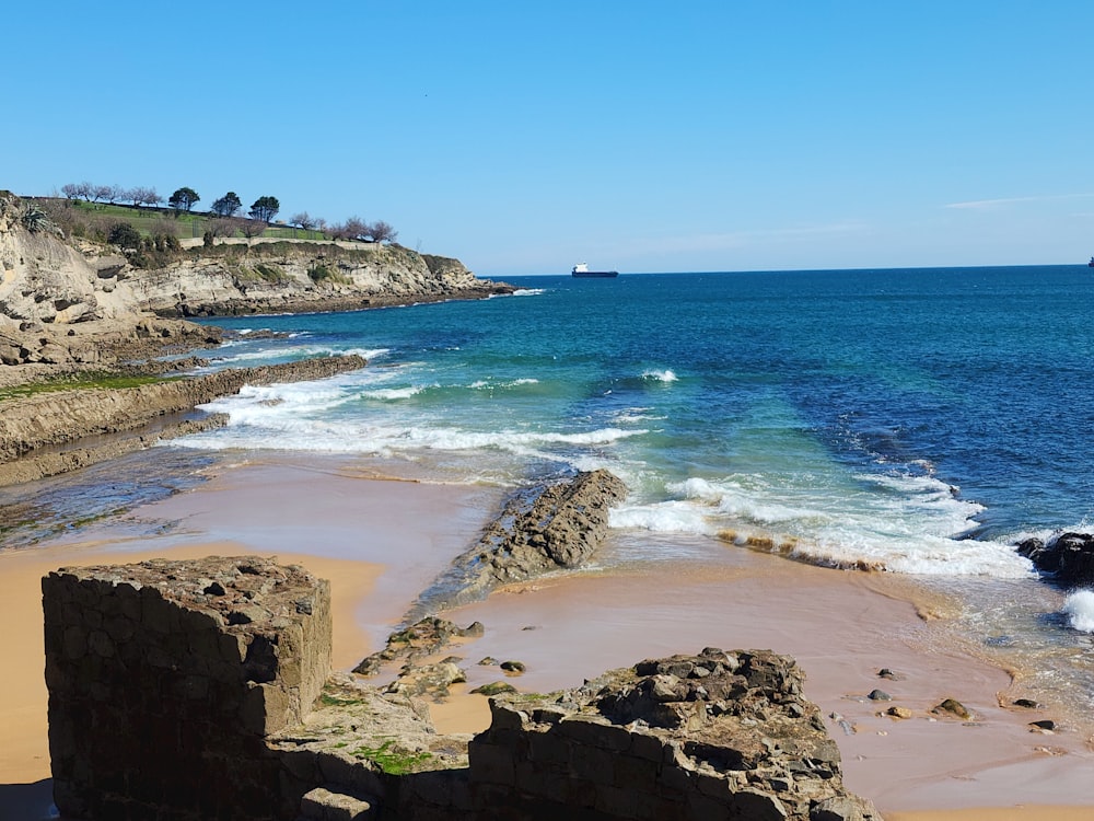 a rocky beach with a body of water in the distance