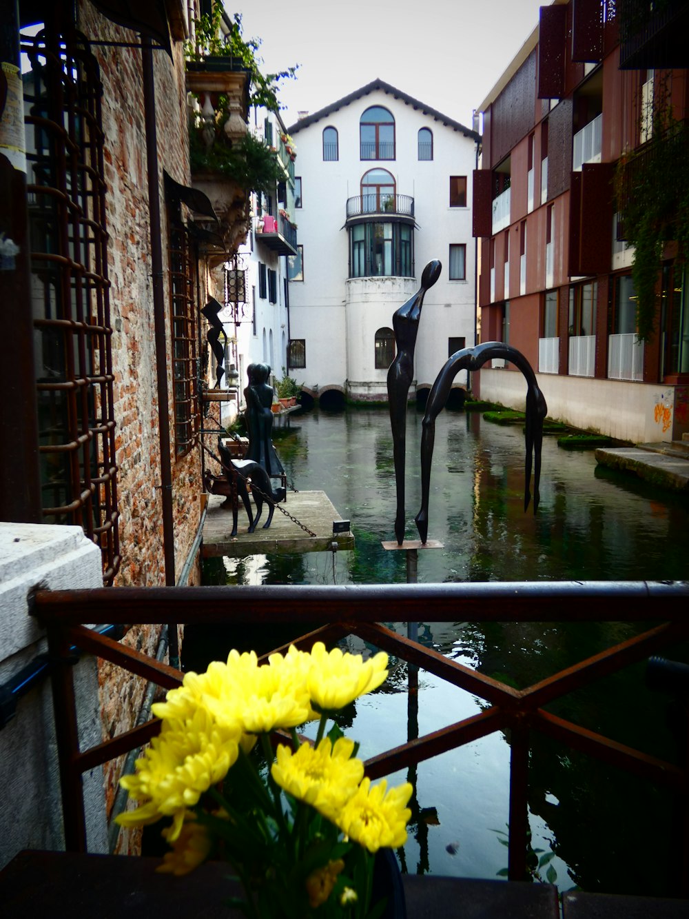 a vase of yellow flowers sitting on top of a window sill