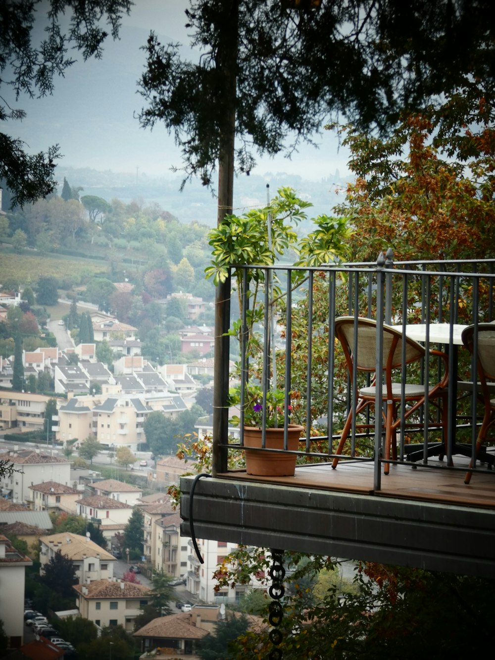 a balcony with a table and chairs overlooking a city