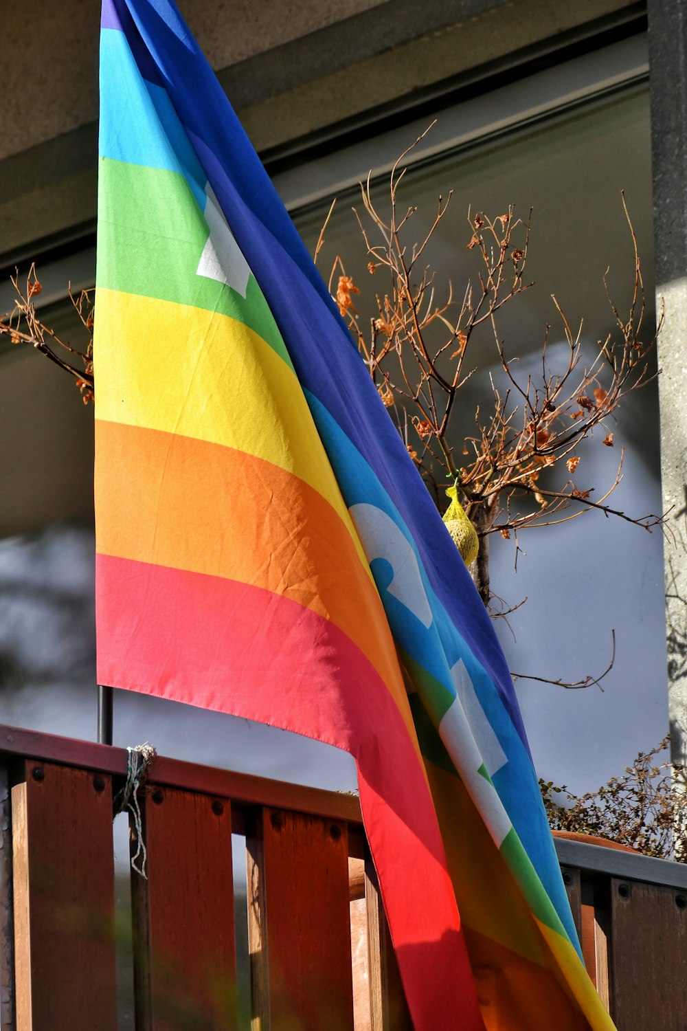 a rainbow colored flag hanging from the side of a building