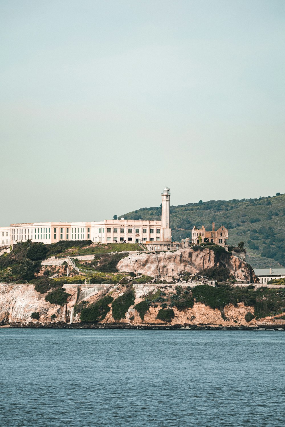 a large building sitting on top of a hill next to a body of water