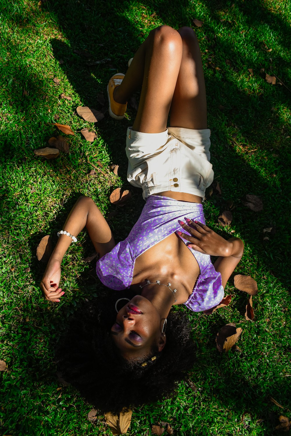 a woman laying on the ground in the grass