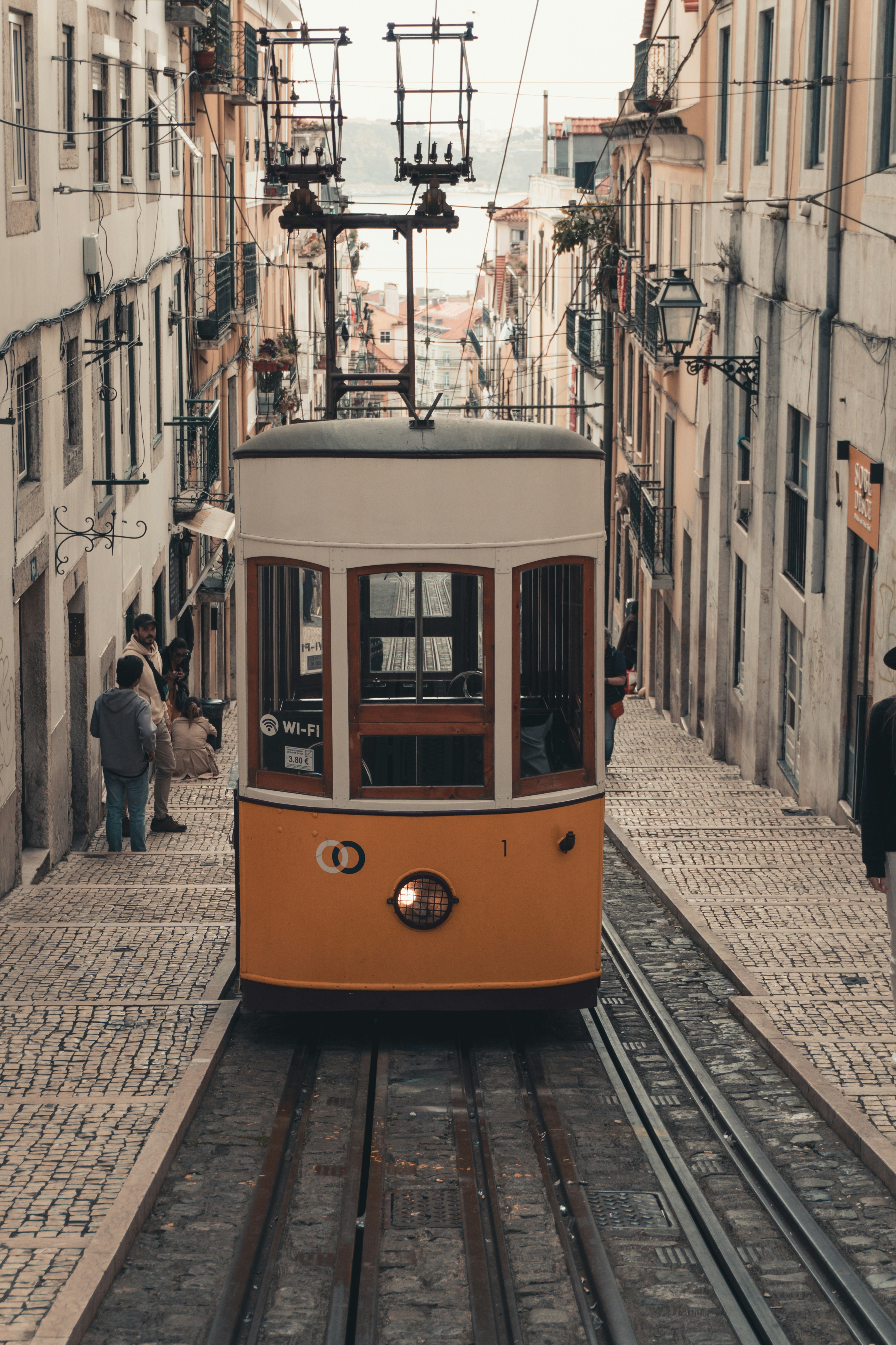 a trolley car traveling down a street next to tall buildings