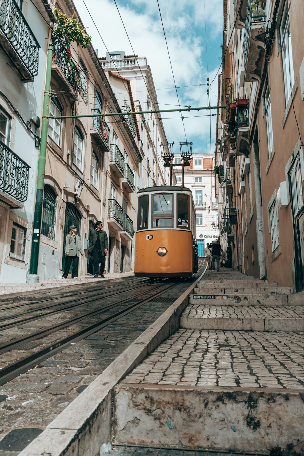 a trolley car is going down a narrow street