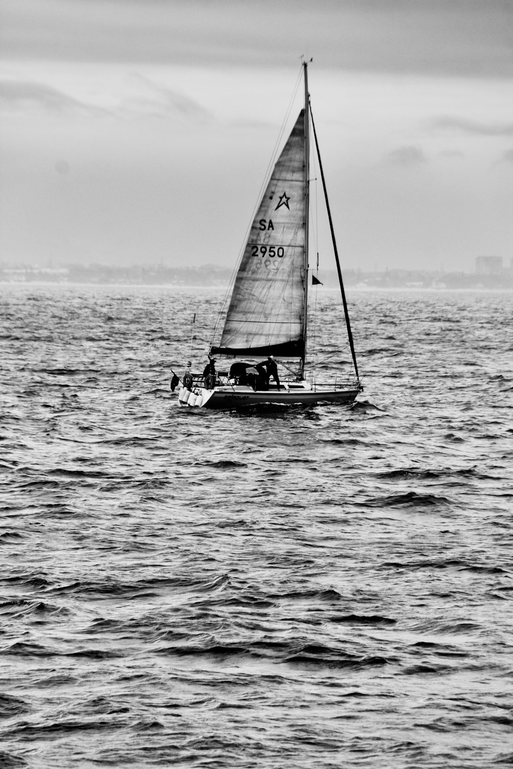 uma foto em preto e branco de um veleiro no oceano