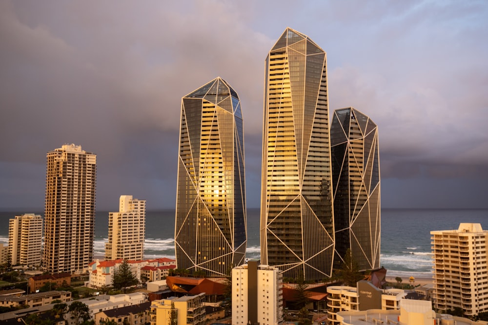 a group of tall buildings next to the ocean