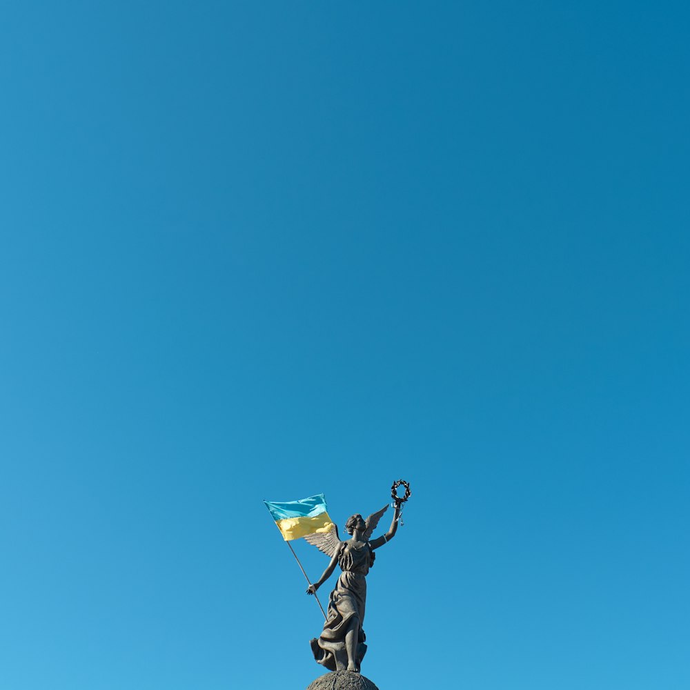 a statue of a woman holding a flag on top of a building