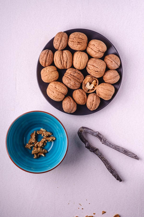 A bowl of nuts next to a bowl of walnuts