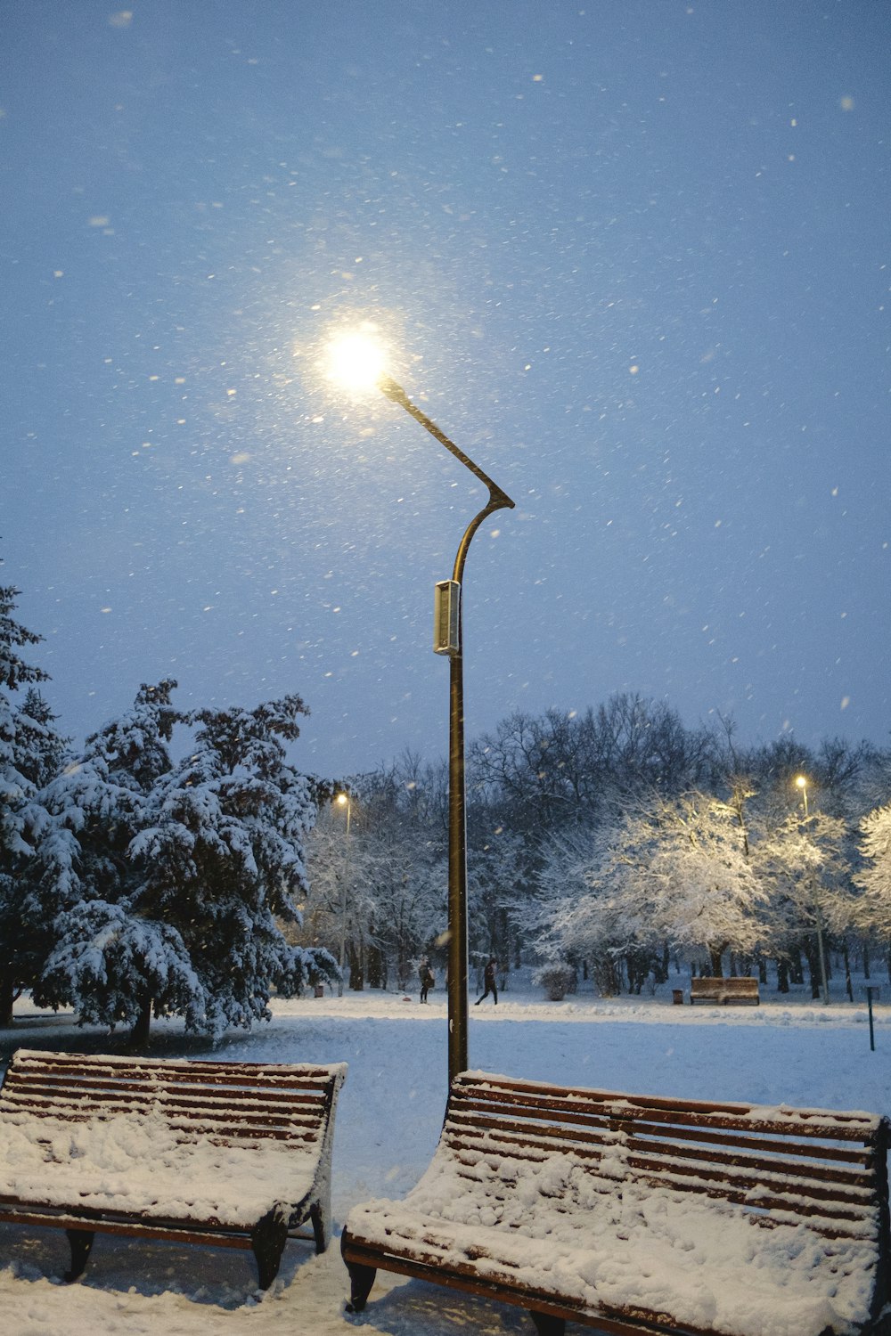 a couple of benches sitting under a street light