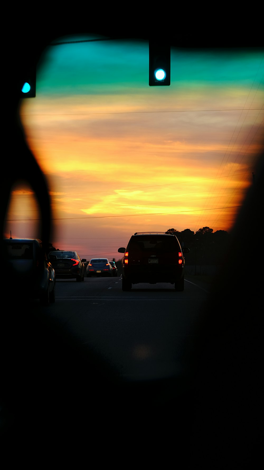 Un coucher de soleil vu à travers le rétroviseur d’une voiture