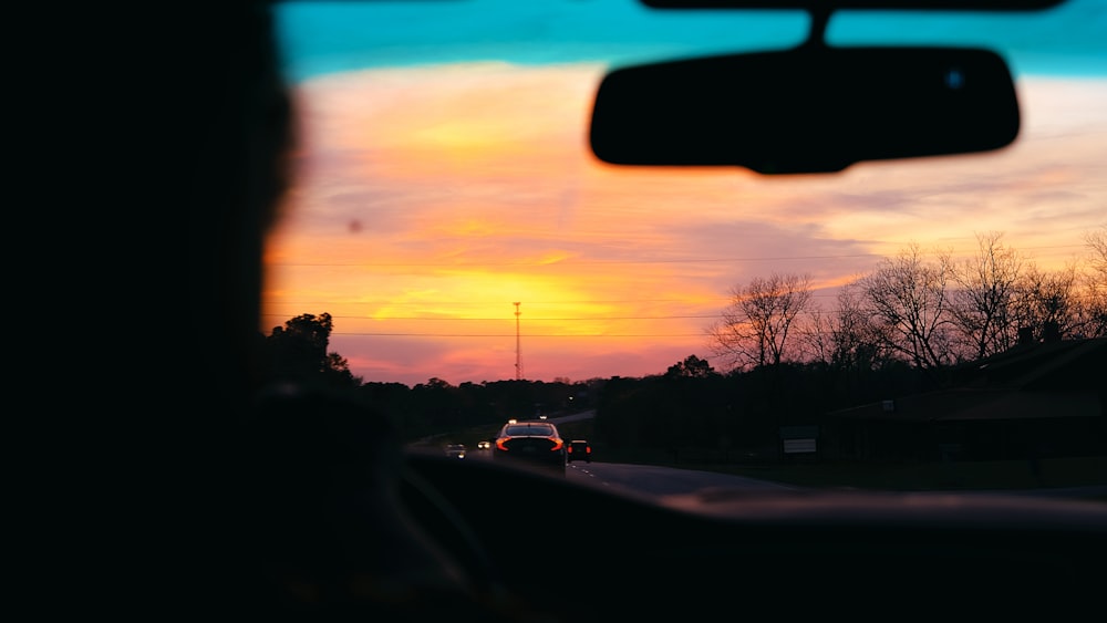 uma vista de um pôr do sol de dentro de um carro